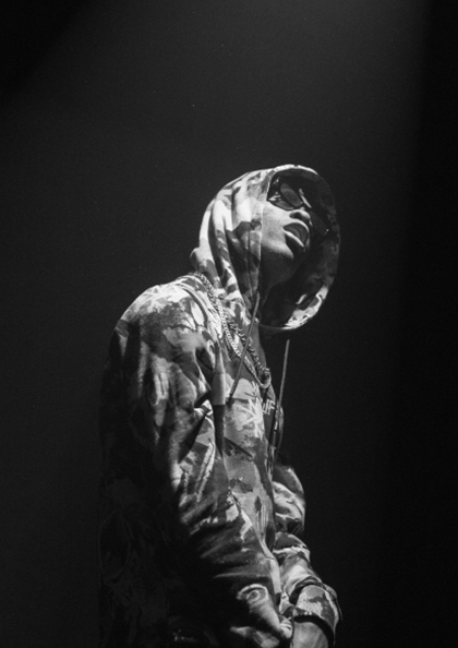 A person wearing a hooded jacket in the dark.